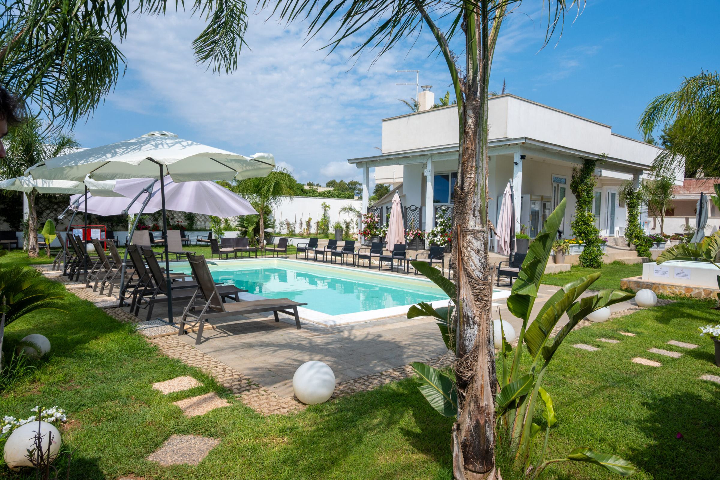 La piscina di Villa Leonardo tra le palme